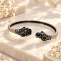 Black and silver-tone adjustable cuff bracelet with ornate detailing and round black accents | SISTERHOODS-SHA256:3b78ebb8a9ff6dcc96fa81906bf54cda55935b7b6fcc3beb843c0ed587ca9a72