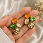 Multicolour gold-toned dangle earrings with orange, green, cream and champagne accents | SISTERHOODS-SHA256:e0032bb0f21274d108f65c26850b550c0f8c39e81cda33b36eb05801af01e92e