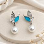 Silver-tone dangle earrings with blue leaf accents, clear embellishments and white round drops | SISTERHOODS-SHA256:1e874091805628ae5e3d628feb71f67d2f961fd95218bba52277b77c2c227e99