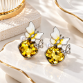 Yellow faceted dangle earrings with white flowers, pearl accents and butterfly details | SISTERHOODS-SHA256:84d9176fa2d5ea83f8688cbab0ebbaa507a729a7a0df33616cbcd847822afaf1