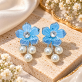 Blue floral dangle earrings with sparkling centre accents and three white pearl drops. | SISTERHOODS-SHA256:ce0b1ad6997ee86c40939d2a9e0db9cb739e1b1e0f1ca45bbbb62f02d5bb0892