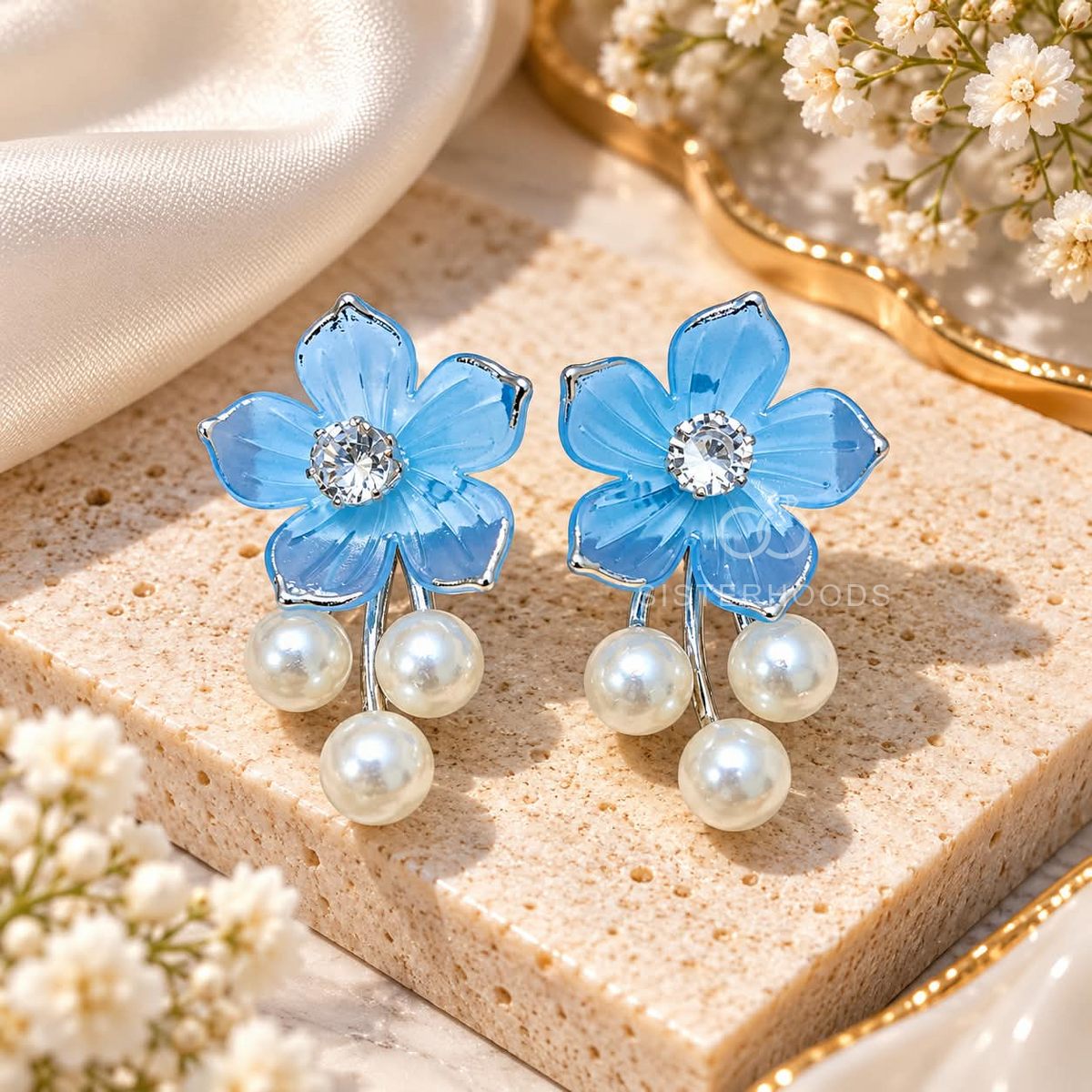 Blue floral dangle earrings with sparkling centre accents and three white pearl drops. | SISTERHOODS-SHA256:ce0b1ad6997ee86c40939d2a9e0db9cb739e1b1e0f1ca45bbbb62f02d5bb0892