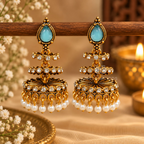 Gold-toned jhumka earrings with blue teardrop accents, clear stones and white bead fringes | SISTERHOODS-SHA256:31bbe18a028478523b9a4018facc9c8ab5b6518f75c737051da0d81215874d21