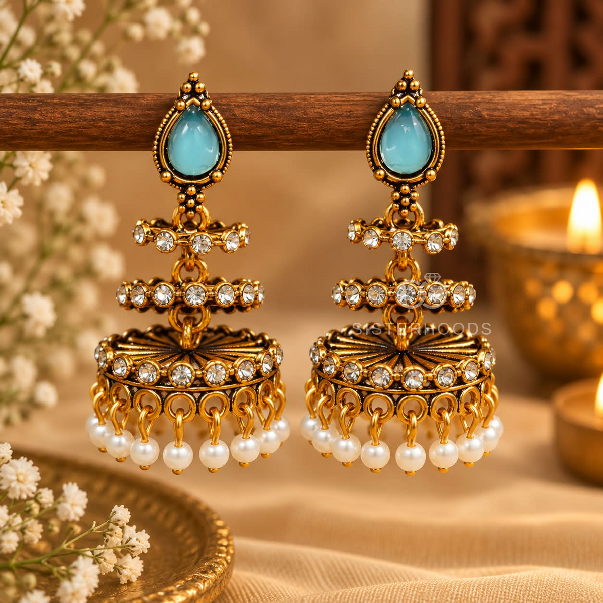 Gold-toned jhumka earrings with blue teardrop accents, clear stones and white bead fringes | SISTERHOODS-SHA256:31bbe18a028478523b9a4018facc9c8ab5b6518f75c737051da0d81215874d21