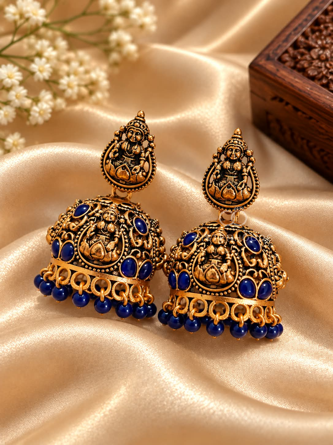 Ornate traditional jhumka earrings with divine motifs and blue bead accents | SISTERHOODS-SHA256:2c6e94d64ae5a06a946e7a569e1883b258b7b002adbd3c81e3d81a818631f316