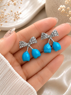 Blue drop earrings with textured bow-shaped accents | SISTERHOODS-SHA256:d83b68f3031cc2f82a6cc9bca83f0eb4e7f05047e03b6715f39b3dd775113ea8