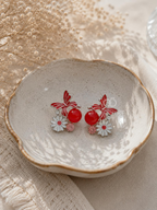 Red butterfly and floral dangle earrings with daisy details | SISTERHOODS-SHA256:bbefc35e12e98daea767e9e8fe0c0bbd251ca93e9a0bd2a8d5161d88664efc97