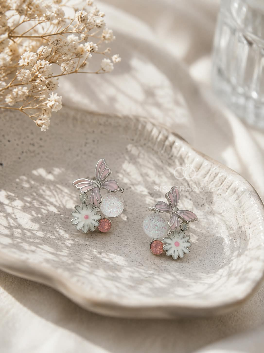 Silver butterfly and flower drop earrings with pink and white details | SISTERHOODS-SHA256:17e8723e5f7def349843c3c7dde25b1814ce1a44883407607547ad245f1497a6