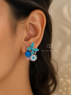 Blue butterfly and daisy stud earrings with white and pink floral accents | SISTERHOODS-SHA256:4243a0588ccb93d02c16e9f40c31bec7097defc4cca773678af02cd12efecdc0