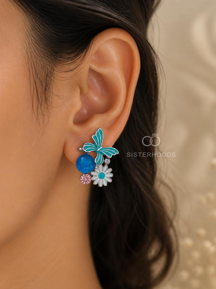 Blue butterfly and daisy stud earrings with white and pink floral accents | SISTERHOODS-SHA256:4243a0588ccb93d02c16e9f40c31bec7097defc4cca773678af02cd12efecdc0