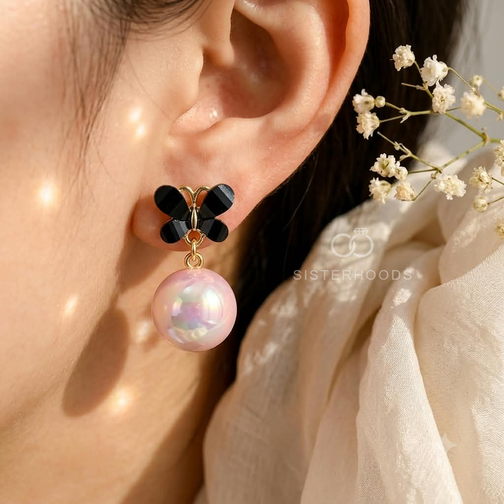 Black floral stud earrings with iridescent pink pearl-style drops | SISTERHOODS-SHA256:ad96a6f080d301d13914e186c1c97268eea7054346dd0ae25aed8e3af526f63e