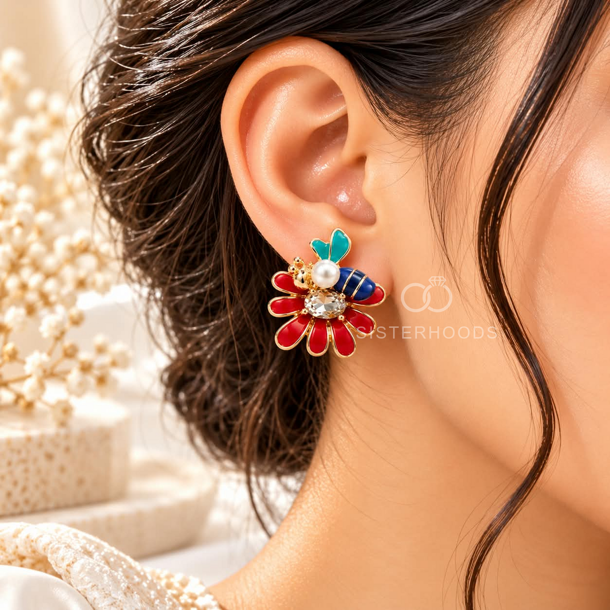 Multicolour floral stud earrings with red petals, blue and turquoise accents, pearl details, and gold-tone outlines | SISTERHOODS-SHA256:dea960657c4cced5da72ca6d58c851fa09ea81f05999700d6d2381aa89ffdd84