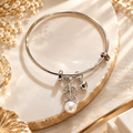 Silver adjustable bracelet with leafy charms, round accent and white pearl-style drop | SISTERHOODS-SHA256:2ffeb8f07b2a59e5fc4c479385f1c9ad0b463d2bd76bdece41b3e83ca68eed83