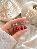 Silver bow drop earrings with red cherry-shaped dangling charms | SISTERHOODS-SHA256:23fa693c987164b667c9bad78848bd22468a732781301e2ca01f236730da4069