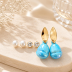 Three pairs of earrings featuring white bead studs, clear accent studs and blue drop earrings with gold-tone leaf tops. | SISTERHOODS-SHA256:af5a377f9480584ca6a913d1b4a3c2d6c379c294ad7911cbed4250de1cab9014