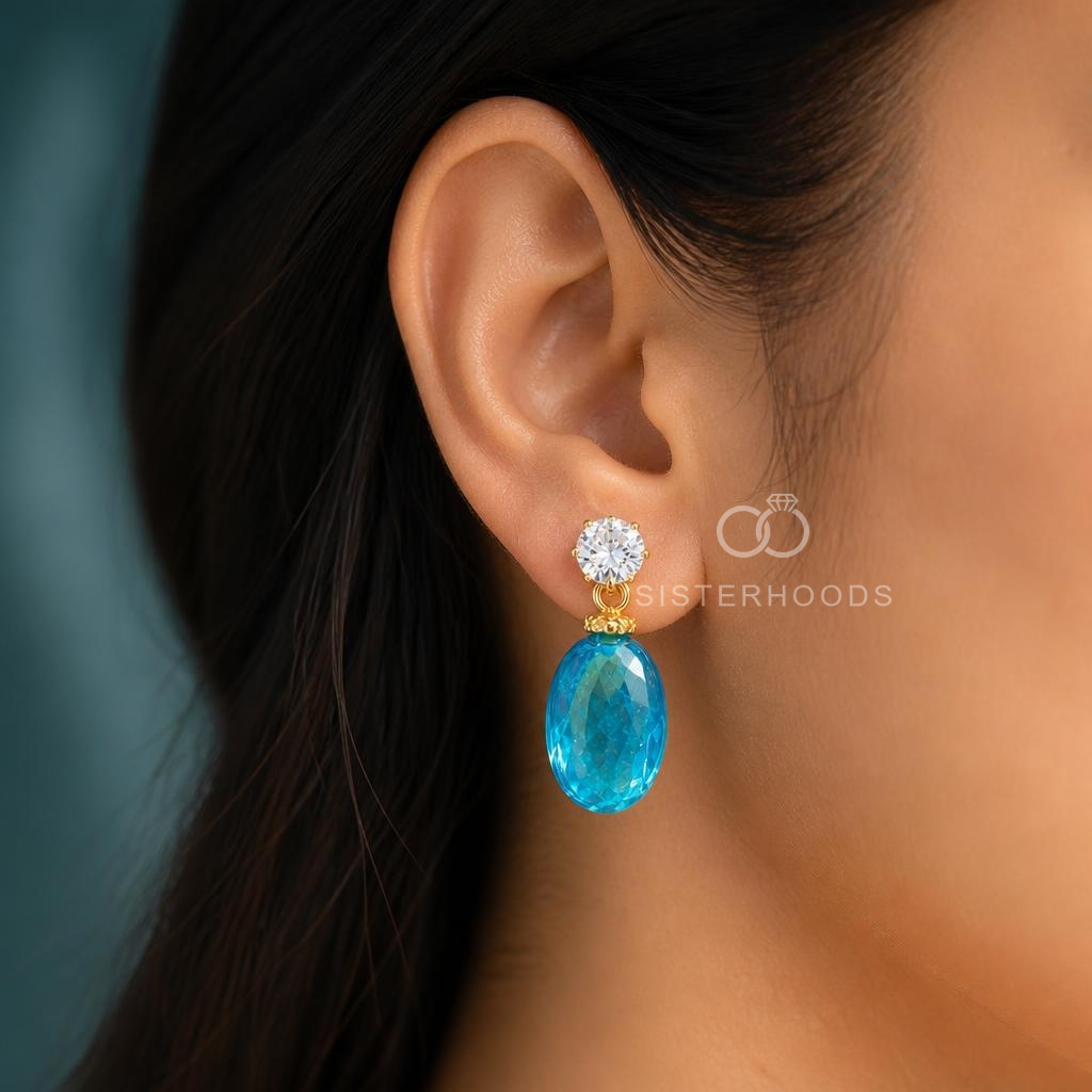 Blue faceted oval drop earring with clear round accent and gold-coloured detailing | SISTERHOODS-SHA256:e87d71427be02448dd26efb2a780de01a299a2f6a6c902f5c7e2c746fa913e09
