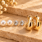 Pearl studs, floral crystal studs and golden hoop earrings arranged together | SISTERHOODS-SHA256:9e442e84dadb9b8beb0bb4120b6b1637314aeab20fba7085a242bfbeabb249cc