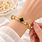 Gold-tone cuff bracelet with black and white clover accents | SISTERHOODS-SHA256:b5b0bbb15e8da01d22084090fa6755acfb82ad79b3347dd65de52b507f4d59f2
