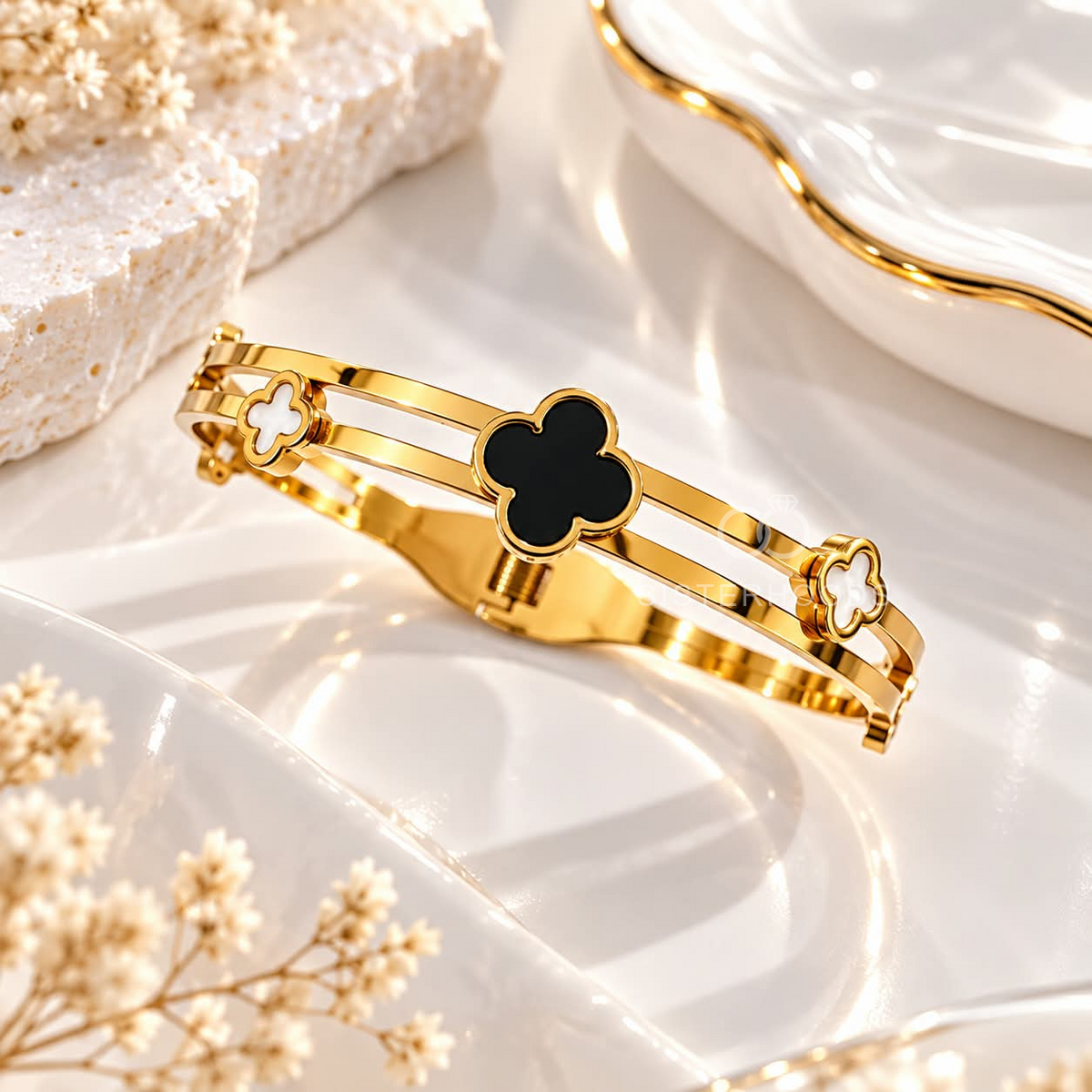 Gold-tone cuff bracelet with black and white clover accents | SISTERHOODS-SHA256:5de78367cd89ae54af05fc6a4b53dfabafee6c376820f359bb74ef1e32400ff8