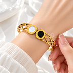 Gold-tone cuff bracelet with black and white circular accents and geometric openwork | SISTERHOODS-SHA256:f9237dba698b87b9d1171c2555e2002f7d6fc2181173cdae8dc3cd3dc69f18f7