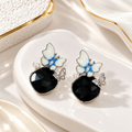 Blue-white butterfly dangle earrings with black faceted drops and pearl accents | SISTERHOODS-SHA256:82bc5b2470901d4be771800f484e9fe56e3170f385c0fea2ce4b55dd0a007350