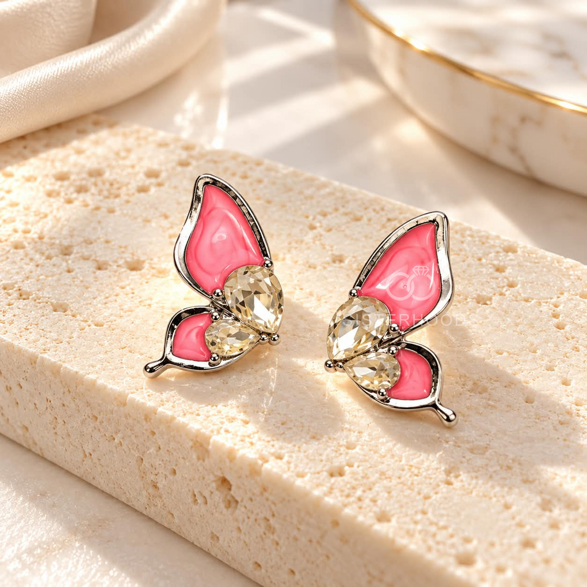 Pink butterfly stud earrings with faceted accents | SISTERHOODS-SHA256:7a86d3ffc49594c8af5cde84935c170e3a719170829b51763f19587aaee96a6d