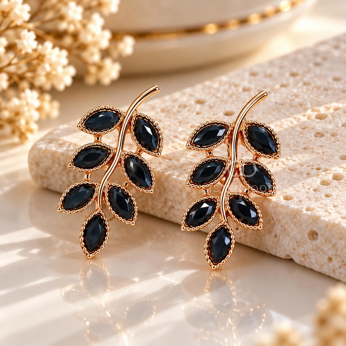 Black faceted leaf stud earrings with a gold-tone botanical branch design | SISTERHOODS-SHA256:c9604711b04c620d9002d4e60e269b9ef96d45fb57fb3dcc22e8f94749549f74