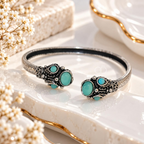 Silver and black open cuff bracelet with turquoise oval accents and ornate detailing | SISTERHOODS-SHA256:7a51ec8eccf77526e450cbe6d5cdb81f8ccc57b3df7c97b5056b6ae21d58f0fc