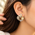 Gold-tone floral cluster stud earring with white petal shapes and sparkling round accents | SISTERHOODS-SHA256:07776e95cf7efab9e5e7bc0e4814aef3d13f94275d1290780f04c2560a2adced