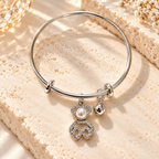 Silver-tone adjustable bracelet with pearl, sparkling accent and dangling charms | SISTERHOODS-SHA256:a938ea8b8eafef8a91ccc76965812befb7ee1169d21cda7a10fde805a2ab4bc6