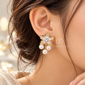 Gold-tone floral dangle earring with white pearl drops and centre accent | SISTERHOODS-SHA256:9ebadab9fcefeda5712b77fa047b8284937dfe676ac298f84b71e4affe8a530c