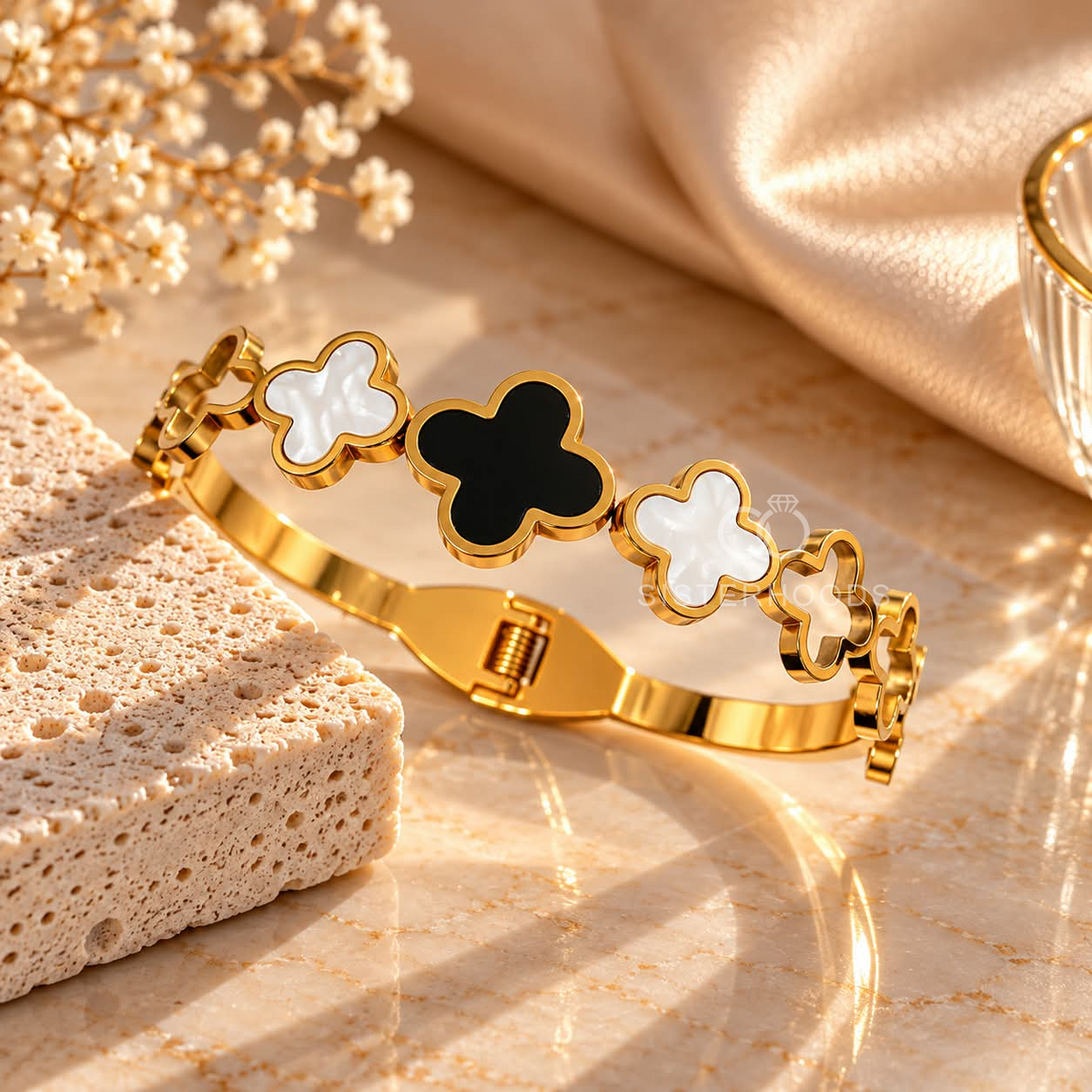 Gold-tone bracelet with alternating black and white clover motifs | SISTERHOODS-SHA256:36c2e171a052da0c0ac562e8d6d7a96f8e76993117c75166dc9d700d80fa9e75