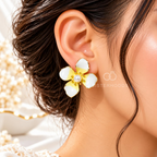 White and yellow floral stud earrings with pearl-like centres and gold-tone detailing | SISTERHOODS-SHA256:b797e831cd11695b4f13669b9d41c51bf14b64136ffd27be423731048bf1da10