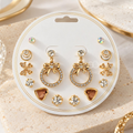 Gold-tone multi-style earring set with studs, bow drops, floral accents and heart-shaped designs | SISTERHOODS-SHA256:88e3d9864a4721064008e6e9ff82a9b4d5ec6d0224221580fa1634c7bb2df164