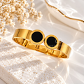 Gold cuff bracelet with twin black circular Roman numeral accents | SISTERHOODS-SHA256:6e6bde47efec5239e032e508d323359c00d8c1394ee55e7999d2977499940514