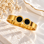 Gold cuff bracelet with twin black circular Roman numeral accents | SISTERHOODS-SHA256:6e6bde47efec5239e032e508d323359c00d8c1394ee55e7999d2977499940514