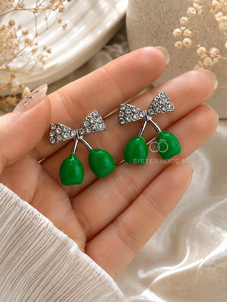 Silver bow-shaped dangle earrings with glossy green drop accents | SISTERHOODS-SHA256:af1a9ddd1042d2c26a4300ab4f72dbf72cb1e6066f4e149033110db658992f6f