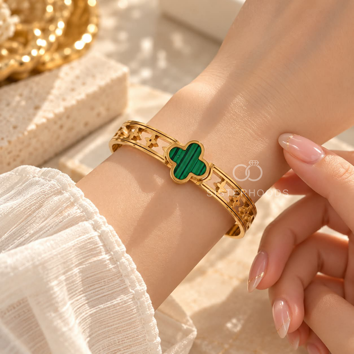 Gold-tone open bracelet featuring a green clover centre and floral cutout details | SISTERHOODS-SHA256:c10db9d1445762b24b616643595b583a889d91f4b2a46d96669c30ed60ecccc6
