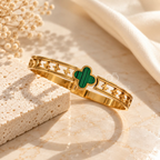 Gold-tone open bracelet featuring a green clover centre and floral cutout details | SISTERHOODS-SHA256:40466c1da7e4707c58a069ef8f5147fd22190bb072672f9c7471a38df71698d1