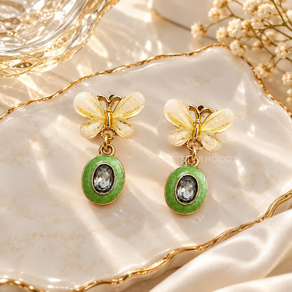 White butterfly earrings with green oval dangling accents and clear centre details | SISTERHOODS-SHA256:c8544a88adfb7701b05a1d4a2a44d441b954251e351df736d0b800103a069ca3