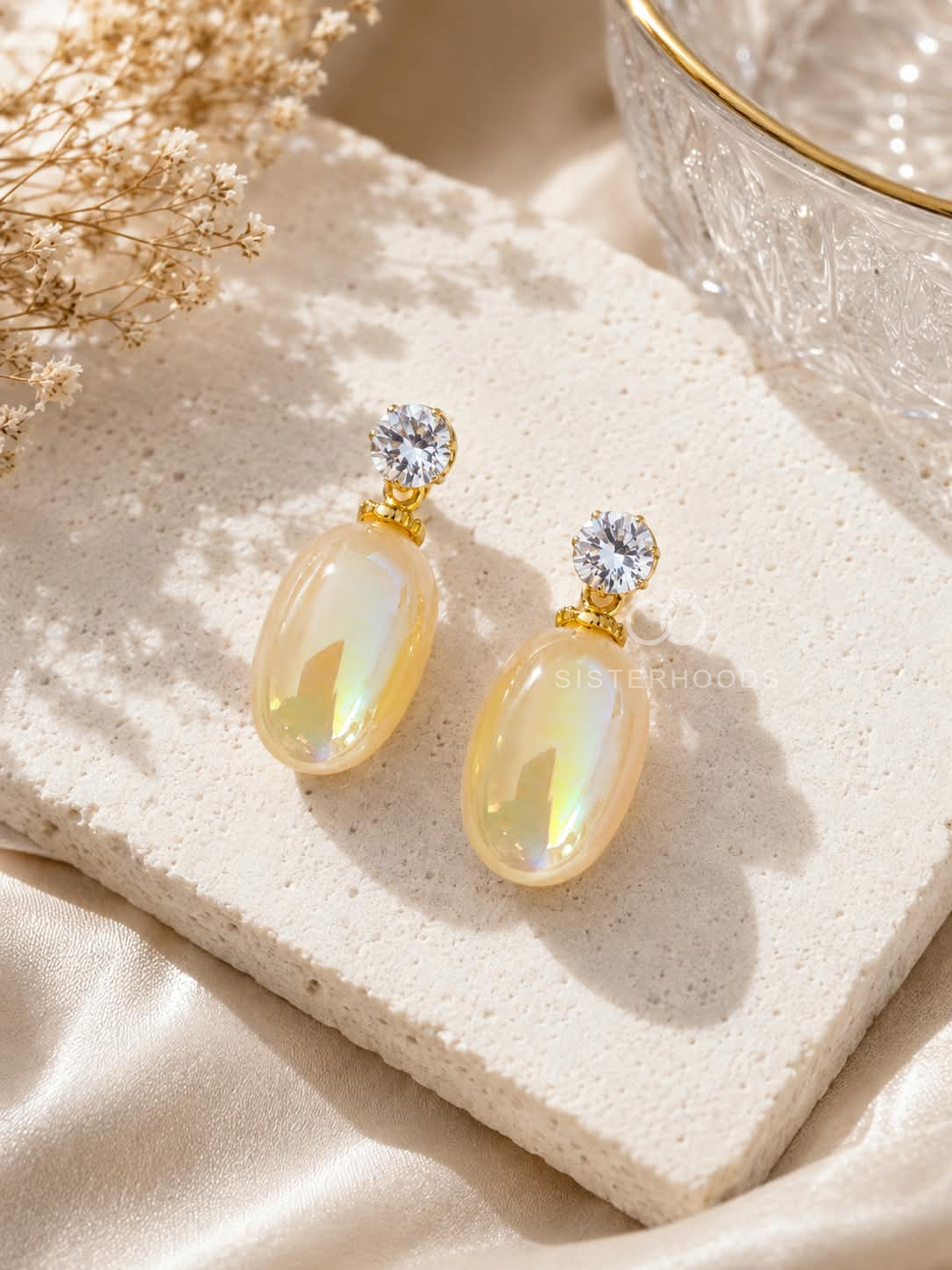 Pale-yellow iridescent oval dangle earrings with clear faceted studs and gold-tone details | SISTERHOODS-SHA256:2f49060289fd517e7bb858d194d6bd89486f6dd15aed0f34d7aba9f0c89c90b8