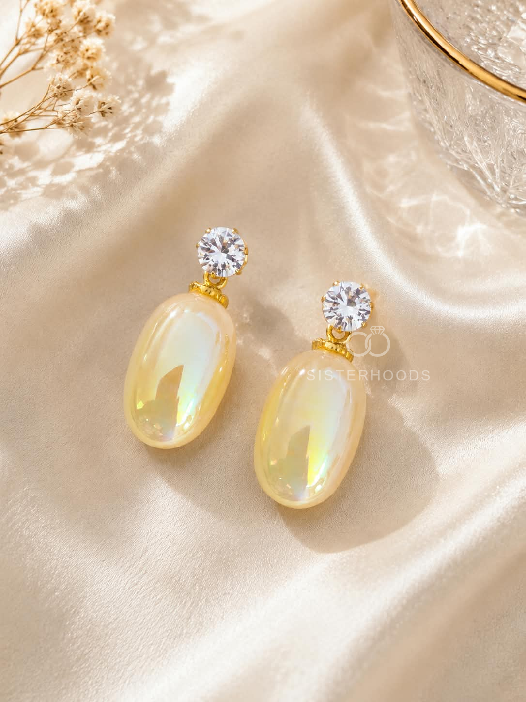 Pale-yellow iridescent oval dangle earrings with clear faceted studs and gold-tone details | SISTERHOODS-SHA256:524d777d9916e3ad60da6766cc70c5243f984bc66b402d2f1f3413b27a84afdc