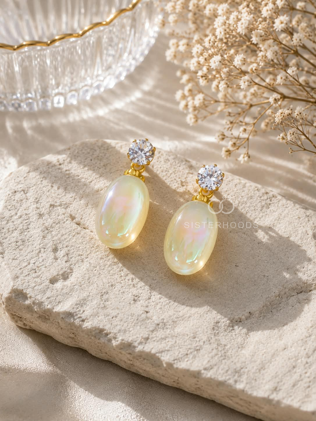 Gold-colour earrings with sparkling round studs and iridescent oval drops. | SISTERHOODS-SHA256:aca060a52a0ad86e5a23f81085a8c75d91609a0d4d29afdd8ef26641d08724af