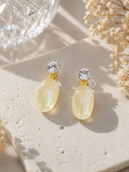 Gold-colour earrings with sparkling round studs and iridescent oval drops. | SISTERHOODS-SHA256:837f3165701f35b9c417f2dfed6502a6d6a116fa2d5c88609abdb4896e206bab