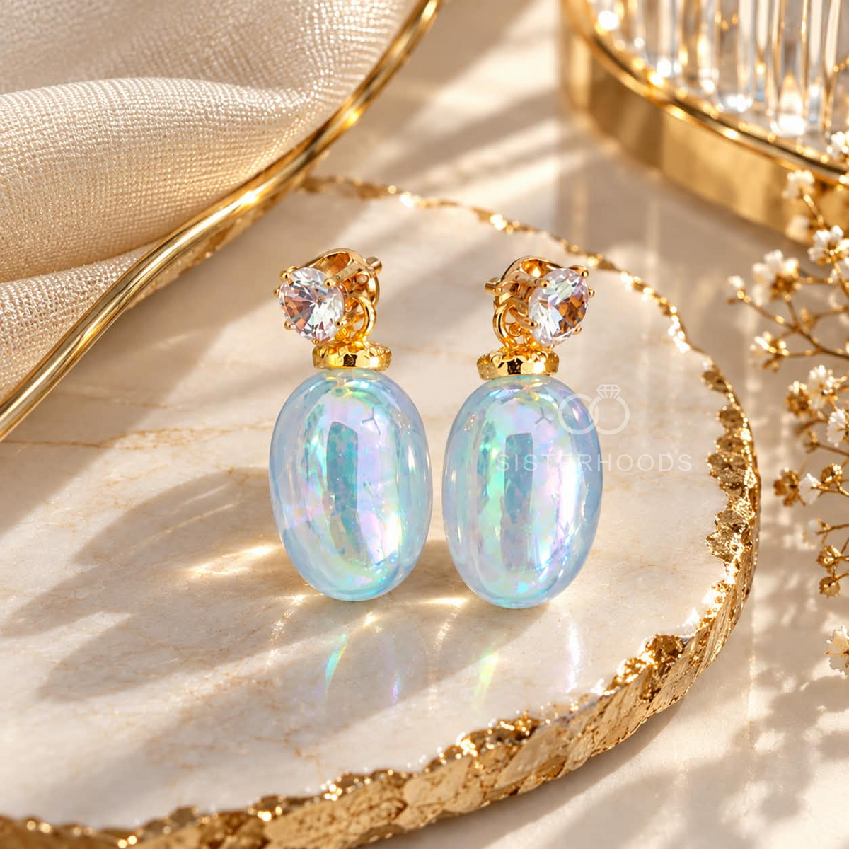 Gold dangle earrings with iridescent blue oval drops and faceted clear accents | SISTERHOODS-SHA256:6fea7024dca4b659f419ef52ec7956af9132996115ee3fc82948c91b36fa7198