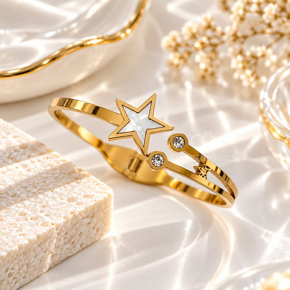 Gold-tone cuff bracelet with a white star centre and clear accent stones | SISTERHOODS-SHA256:85f325e7be0fbeac0a434184f2657b6c9ed3713aa0595536a19ff5e6527db3ac