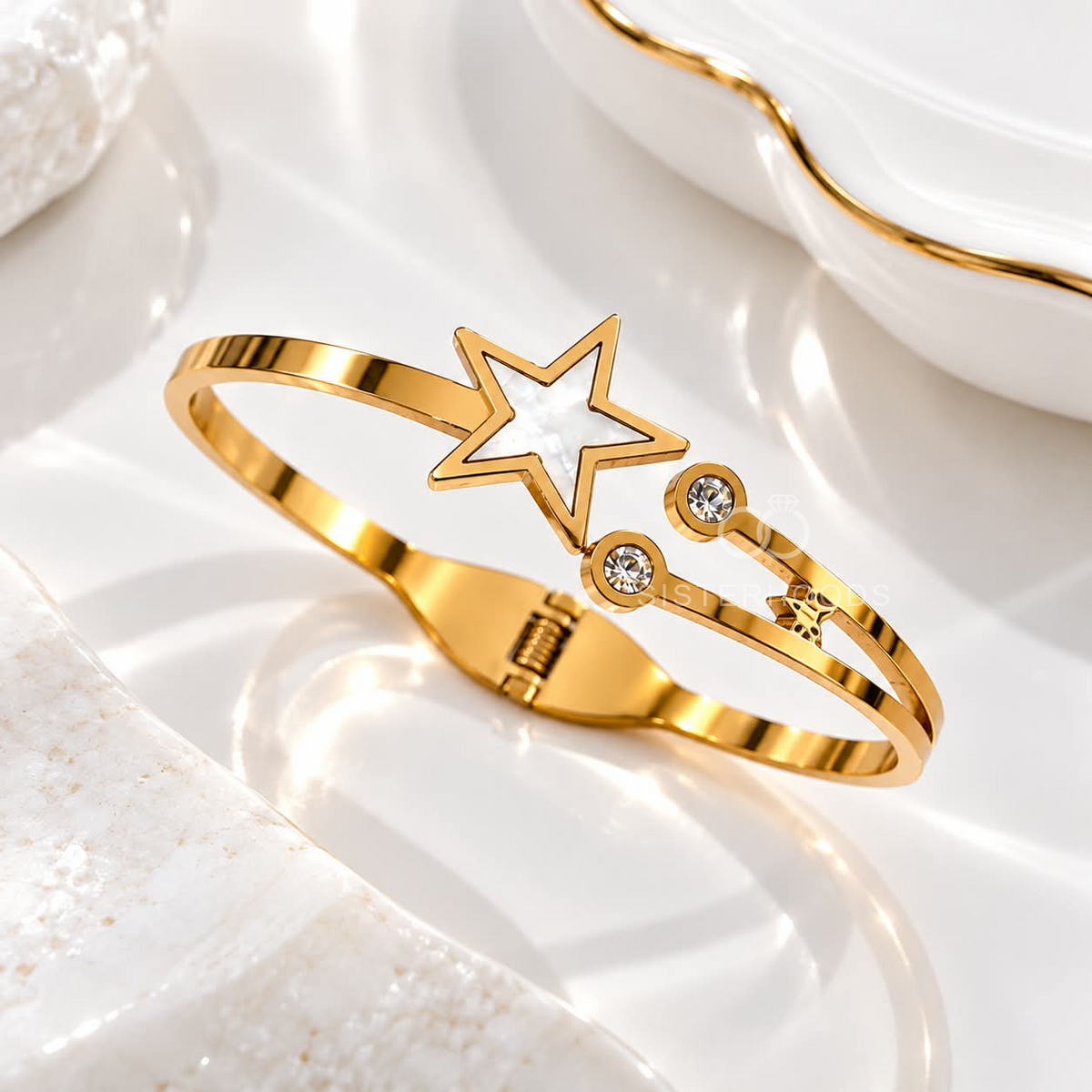 Gold-tone cuff bracelet with a white star centre and clear accent stones | SISTERHOODS-SHA256:3e9392e32e8765c34ce0cfc57b2491d33f1196a13b2908bfc3f6da5dfb958c97