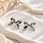 Reflective silver bow-shaped stud earrings | SISTERHOODS-SHA256:34c5c680692e0ece73e42447e152a4db39d8143fbe79df408be465d20fed23af