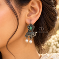 Oxidized silver tone elephant and lotus dangle earrings with green centre details and white bead drops | SISTERHOODS-SHA256:97a2e21d279d26db7d948da698af7853976d5ae1a96432e670f35458b28ebf1a