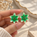 Glossy green floral stud earrings with gold-tone outlines | SISTERHOODS-SHA256:73152b4e8a9f295fae8cc136c6bd761658c9cb91fdd8032ba872f2ce2c00857e